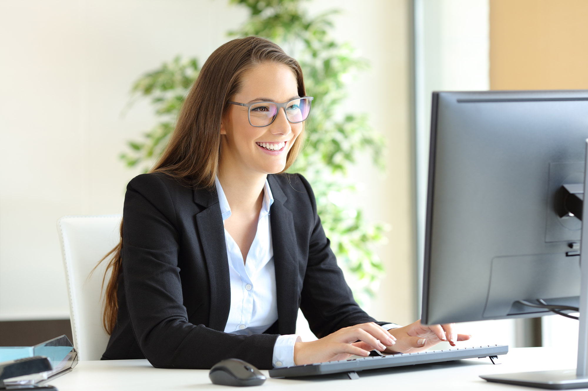 An insurance agent taking notes on a computer.