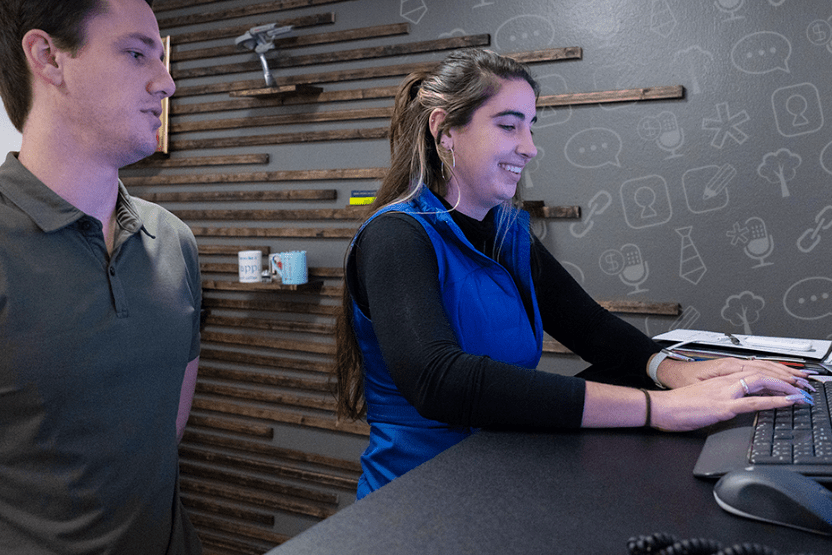 Two Lead Concepts employees inside a working space, with the female employee typing on a keyboard