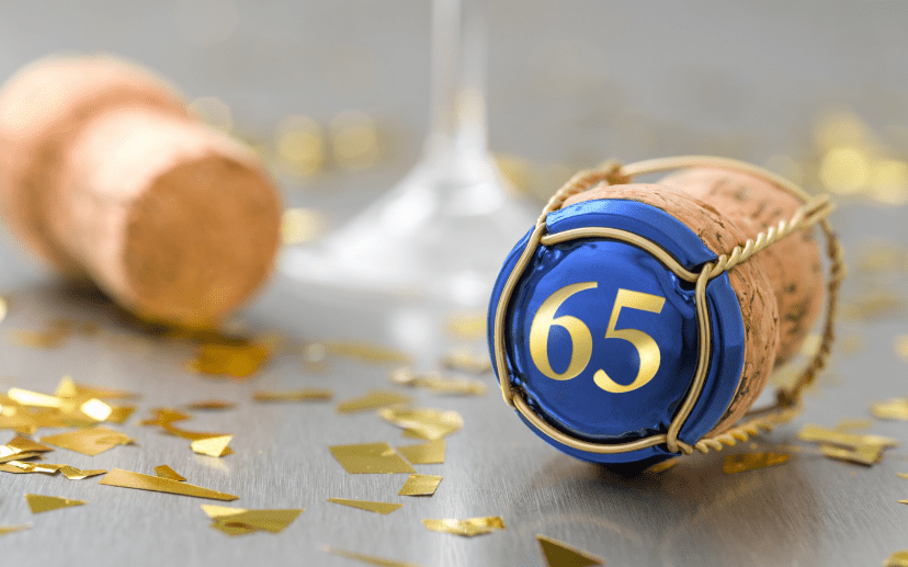 A cork marked with the number 65 alongside a glass of champagne